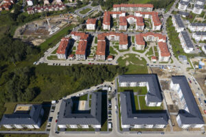 Seniorfinanzierung. Luftaufnahme eines neuen Wohnviertels mit vielfältiger Architektur und grünen Flächen.