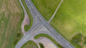 Alternative Lending. Luftaufnahme eines Straßenkreuzungs über malerische Sommerwiesen in der deutschen Landschaft.